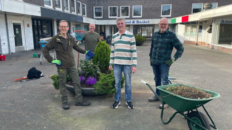 Vier mannen aan het werk op het binnenplein winkelcentrum.